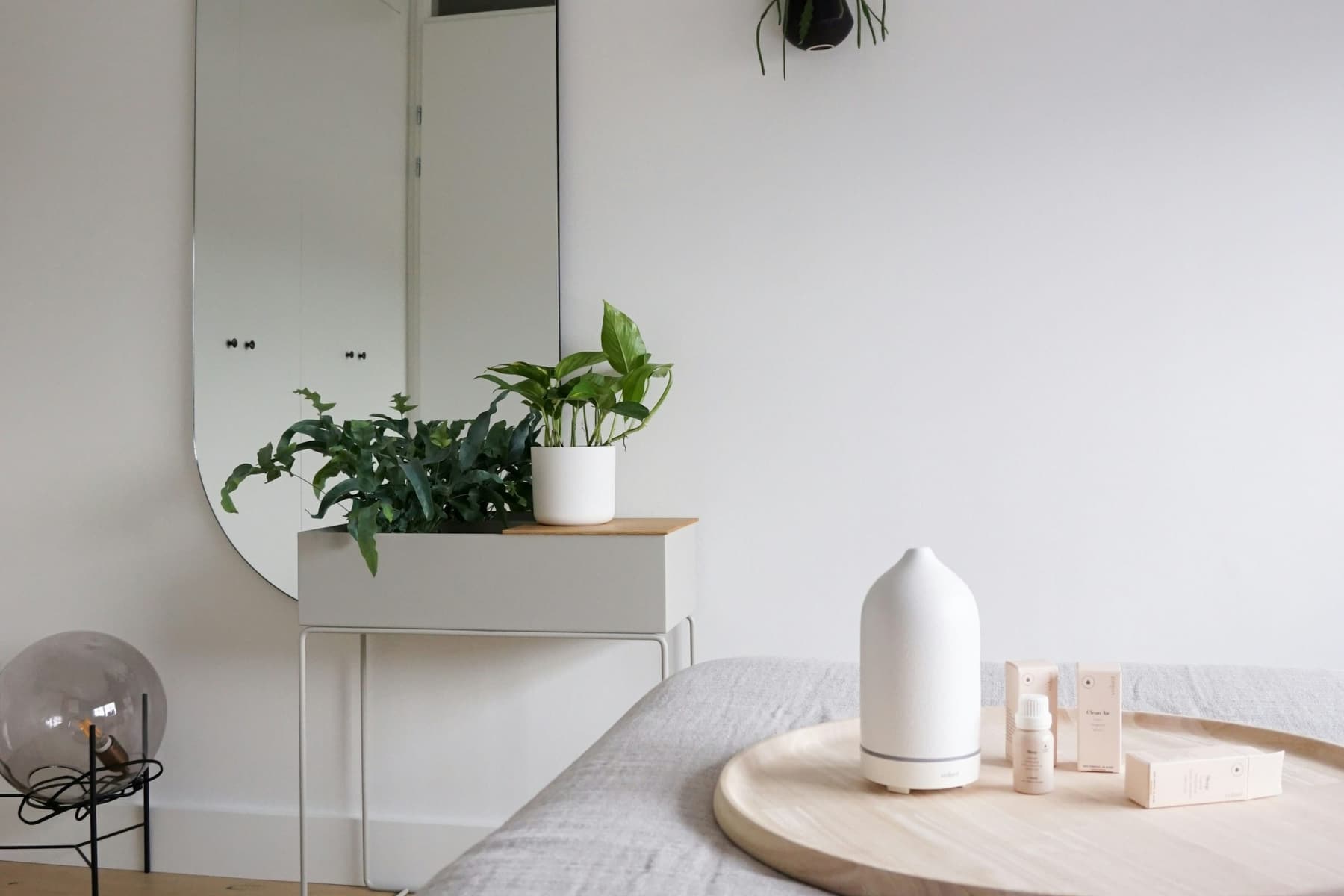 Bright treatment room at the Solenne studio with plants, an oval mirror, and a diffuser